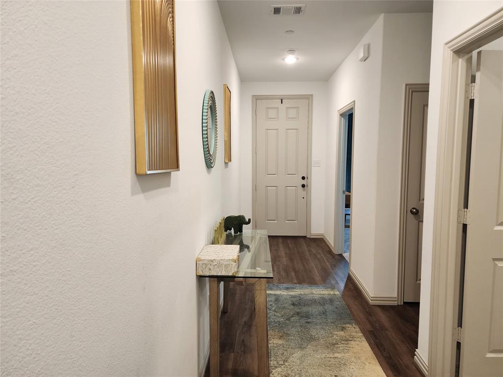 4704 Haltom Road Haltom City, TX 76117 - Photo 3 of 28 a view of a hallway with wooden floor and a bathroom
