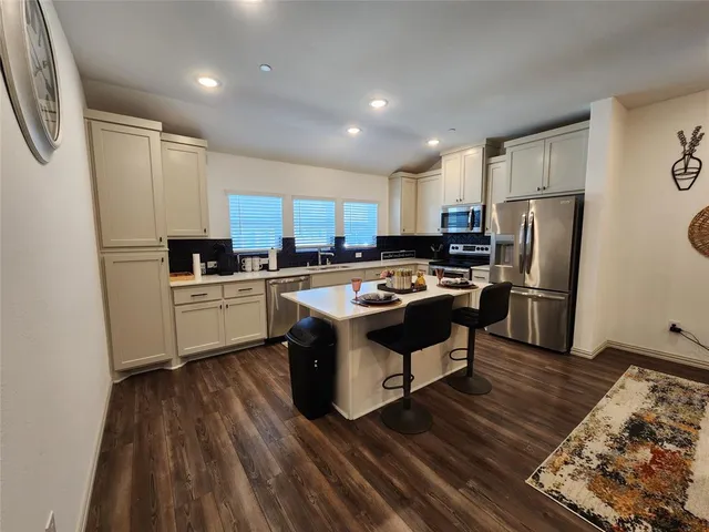 a kitchen with a sink a counter top space stainless steel appliances and cabinets