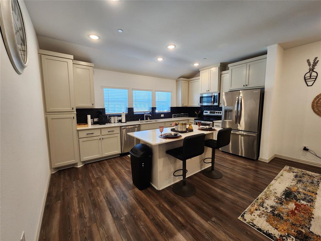 4704 Haltom Road Haltom City, TX 76117 - Photo 5 of 28 a kitchen with a sink a counter top space stainless steel appliances and cabinets