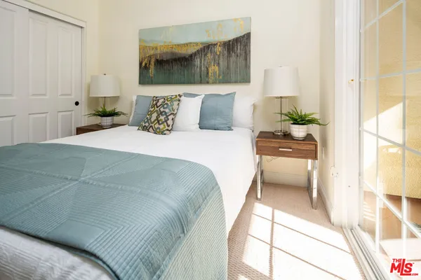 a bedroom with a bed and a large window