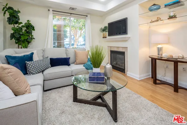 a living room with furniture a flat screen tv and a fireplace