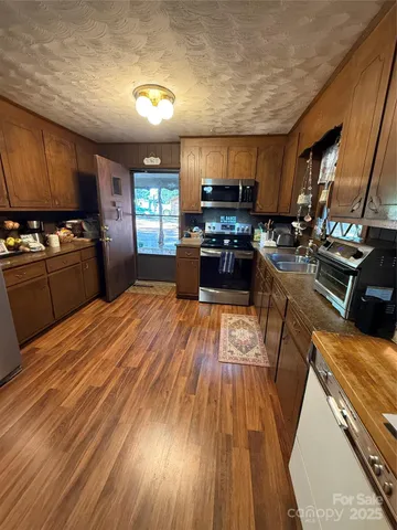 a large kitchen with kitchen island a large counter space a sink appliances and cabinets