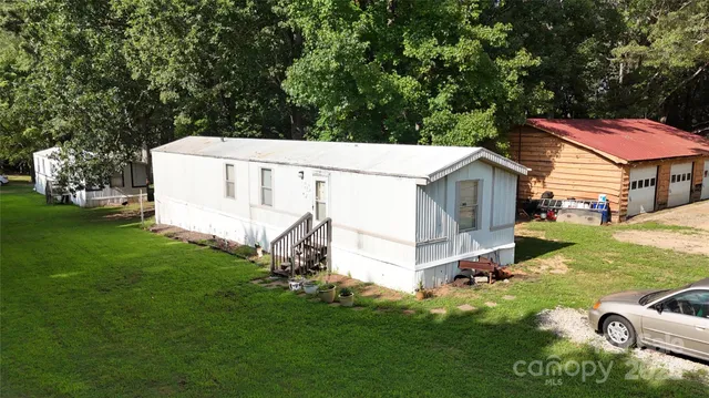 a aerial view of a house with swimming pool next to a big yard