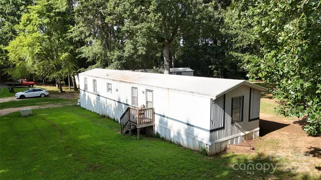 a view of a house with a yard and wooden fence