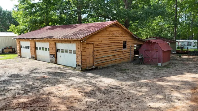 an aerial view of a house with a yard and large trees