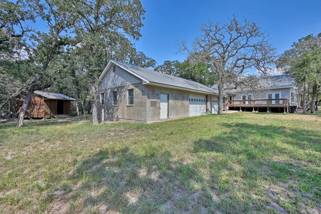 a view of house with a small yard and large tree