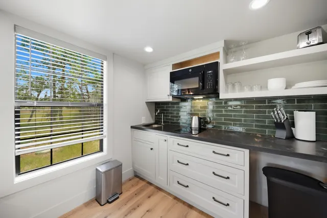 a bathroom with a granite countertop sink toilet and large mirror
