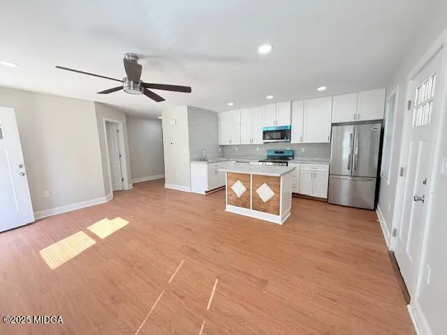 a open kitchen with stainless steel appliances granite countertop a refrigerator and a stove top oven