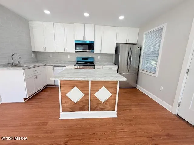 a kitchen with wooden floors and wooden cabinets
