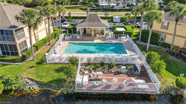 an aerial view of a swimming pool with lawn chairs