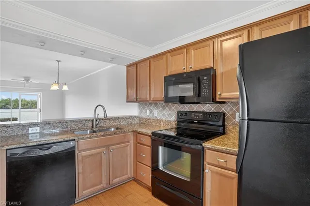 a kitchen with a sink appliances and cabinets