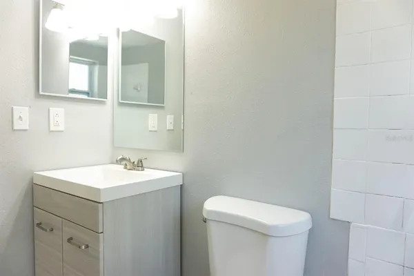 a bathroom with a toilet sink and mirror