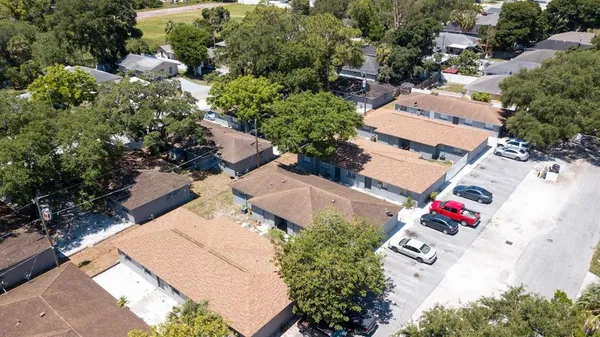 an aerial view of residential house with outdoor space and covered with trees