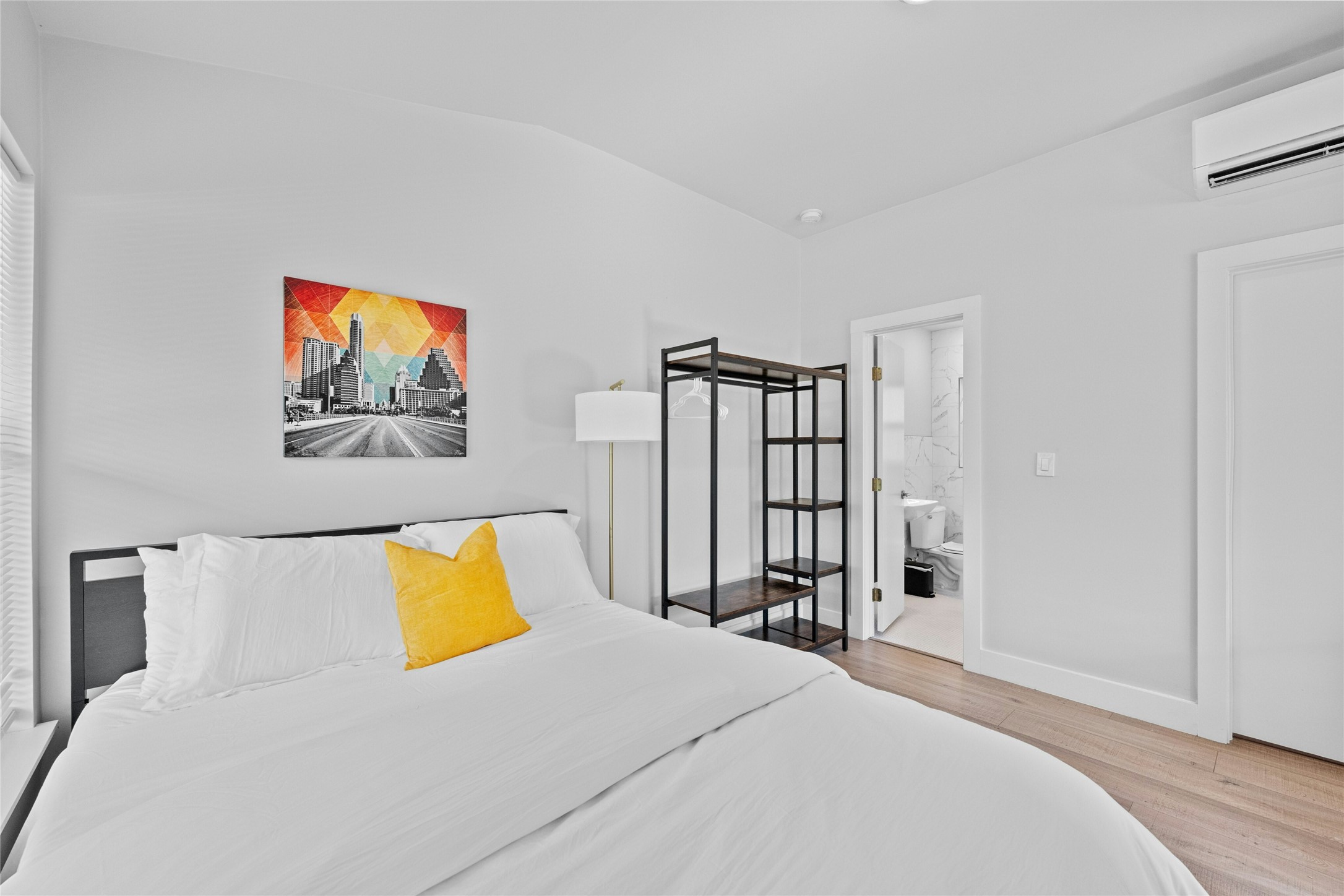 2201 Leon Street, Unit D Austin, TX 78705 - Photo 15 of 24 Bedroom featuring lofted ceiling, hardwood / wood-style flooring, a wall mounted AC, and ensuite bathroom