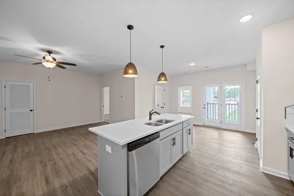 an empty room with wooden floor fan and windows