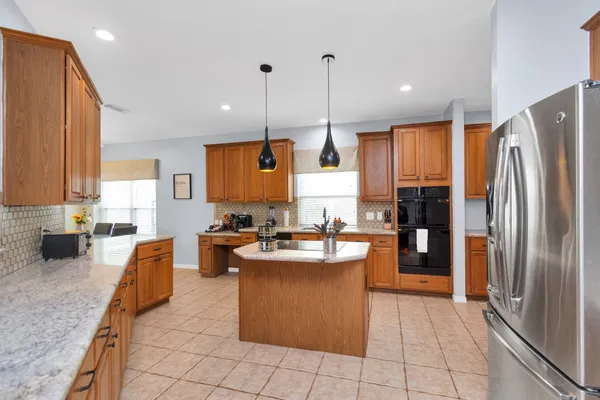 a kitchen with stainless steel appliances granite countertop a stove a sink and a refrigerator