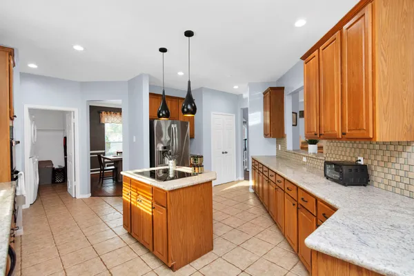 a kitchen with kitchen island granite countertop a sink counter top space appliances and cabinets