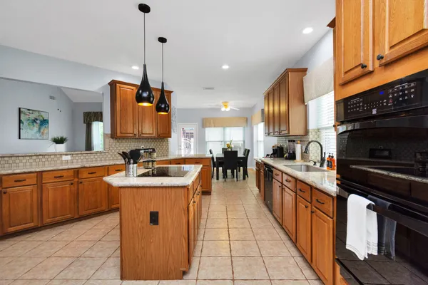 a kitchen with stainless steel appliances granite countertop a sink a stove top oven a counter space and cabinets