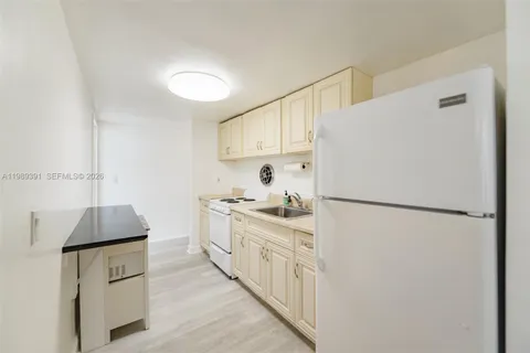a kitchen with stainless steel appliances a refrigerator sink and white cabinets