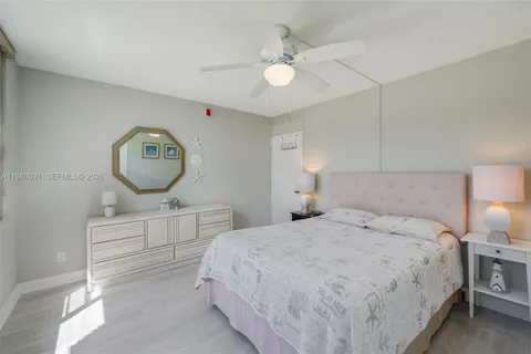 a bedroom with a bed a mirror on dresser and a chandelier