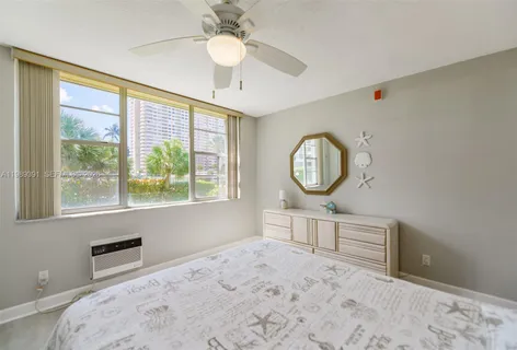 a bedroom with bed and a large window