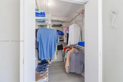a view of walk in closet with clothes and shoes