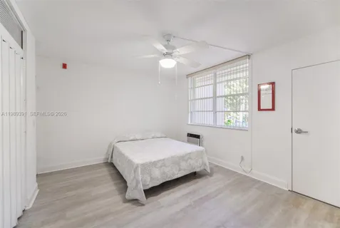 a spacious bedroom with a bed and a window