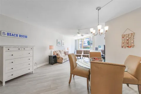 a dining room with furniture a chandelier and wooden floor