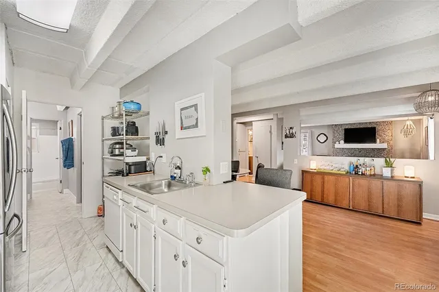 a kitchen with stainless steel appliances kitchen island granite countertop a sink and a refrigerator