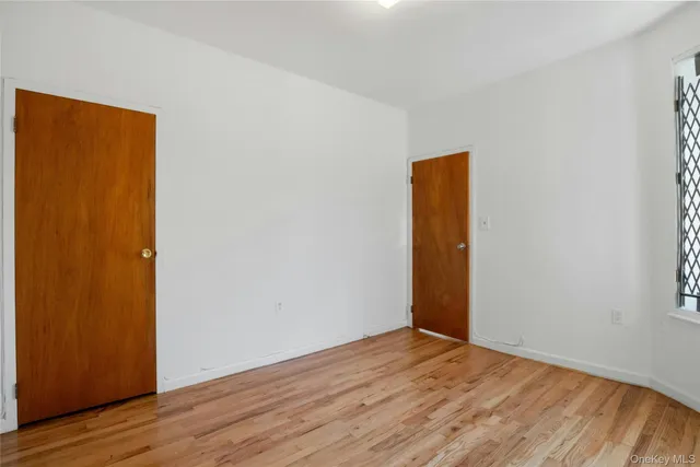 an empty room with wooden floor and closet