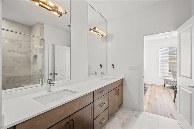 a bathroom with a double vanity sink a mirror and a shower