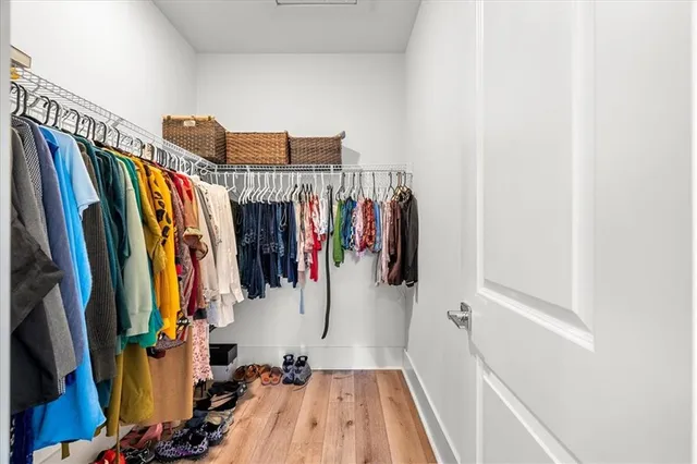 a view of walk in closet with clothes and shoes