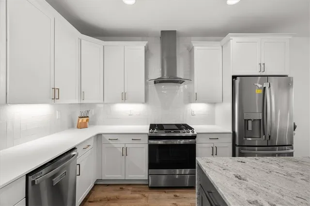 a kitchen with granite countertop a sink a stove and refrigerator