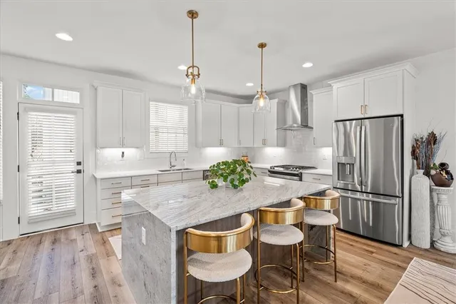a kitchen with kitchen island white cabinets and stainless steel appliances