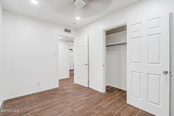 a view of empty room with wooden floor