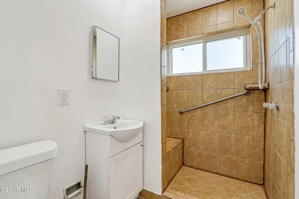 a bathroom with a sink a toilet and shower