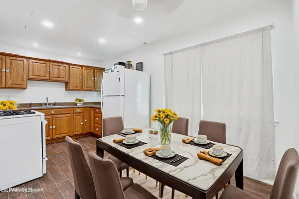 a open dining room with stainless steel appliances a table and chairs