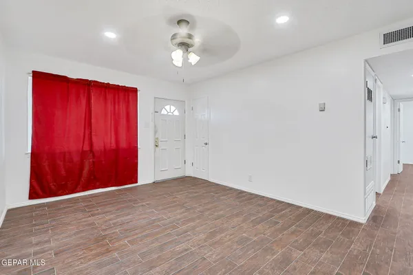 a view of empty room with wooden floor