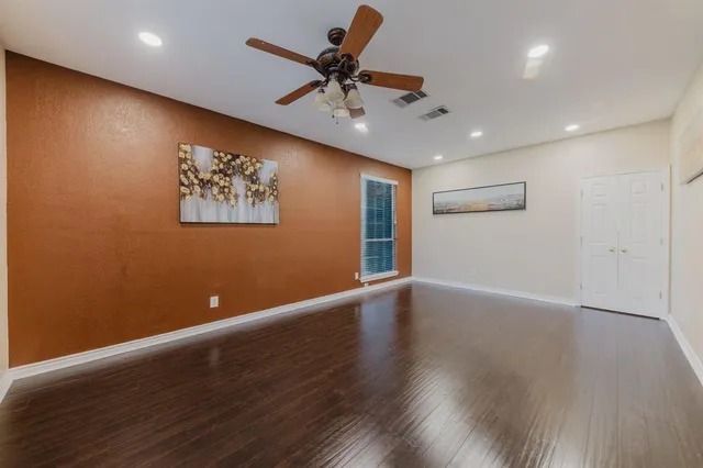 an empty room with wooden floor and windows
