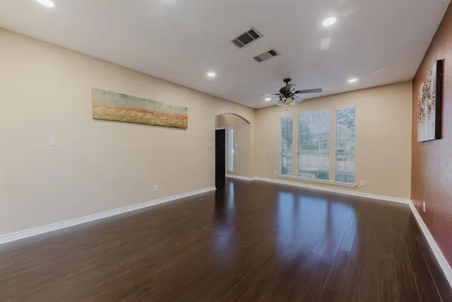 a view of an empty room with a fireplace and wooden floor