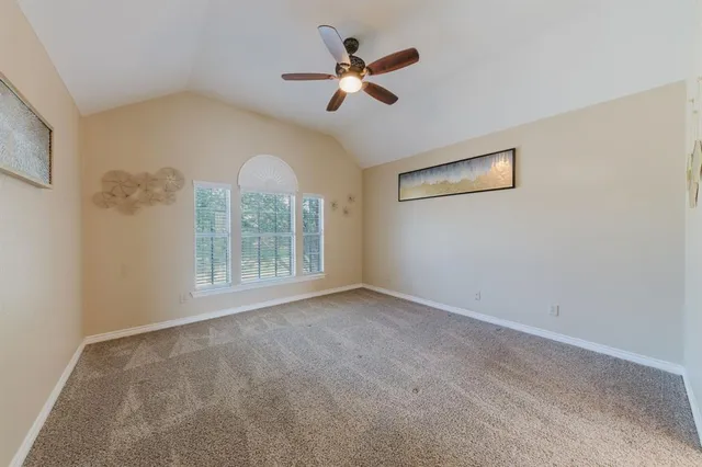 an empty room with closet and a chandelier fan