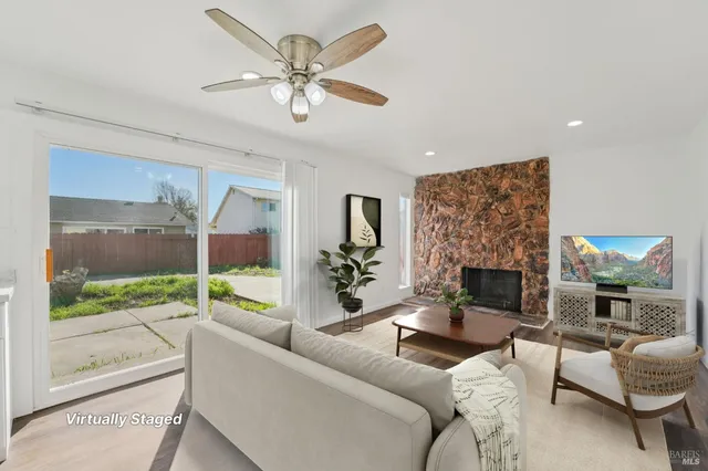 a view of an empty room with a fireplace and a window