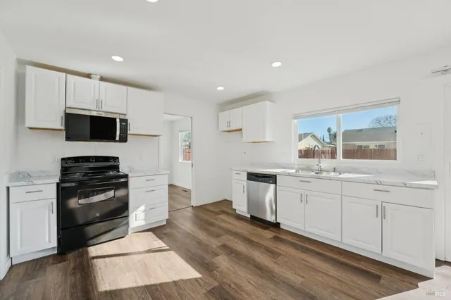 a view of a kitchen with a sink and a refrigerator