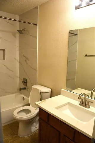 a bathroom with a toilet sink vanity tub and shower