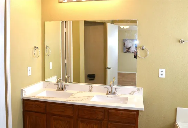 a bathroom with a double vanity sink and mirror