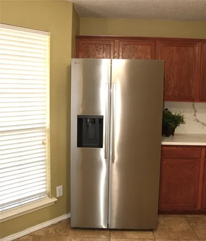 a view of a refrigerator in kitchen and wooden floor
