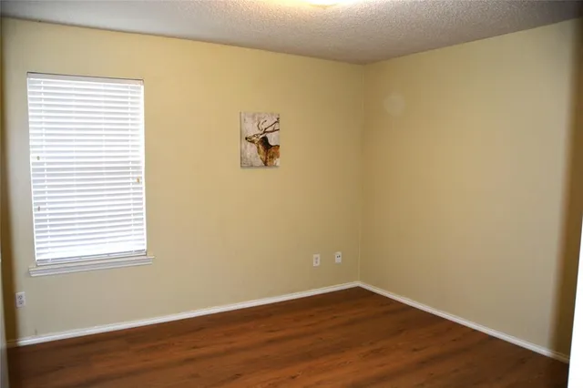 a view of a small space with wooden floor and a window