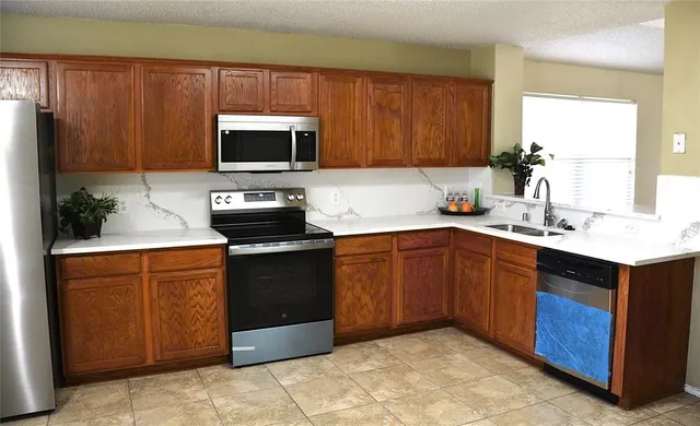 a kitchen with a sink stove and microwave