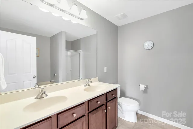 a bathroom with a double vanity sink toilet and a mirror