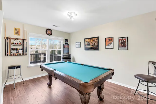 a room with pool table and windows